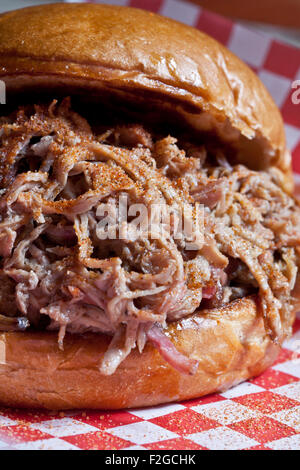 Close-up vertical de sandwich de porc sur du papier rouge à carreaux deli Banque D'Images