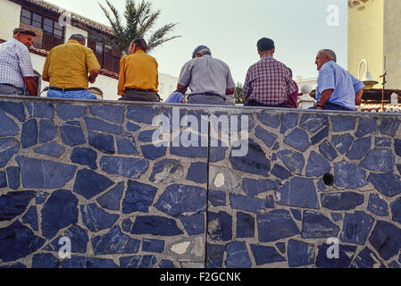 Un groupe de villageois hommes assis sur un mur. Castell de Ferro. L'Espagne. L'Europe Banque D'Images