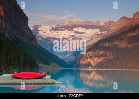 Canoës rouge au Lac glaciaire Louise avec Victoria Glacier, Banff National Park, Alberta, Canada Banque D'Images