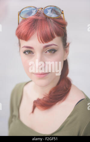 Portrait d'une jeune femme rousse beau portrait à la caméra, dans la sérénité, l'insouciance sereine - Notion - wearing green Banque D'Images