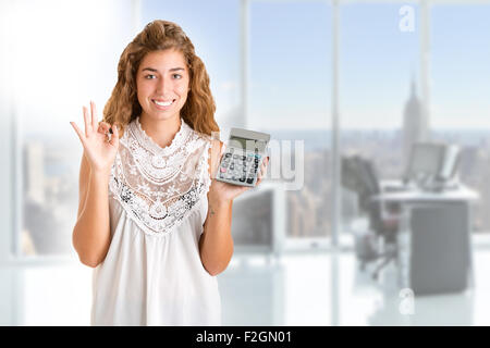 Happy woman holding une calculatrice dans un fond blanc Banque D'Images