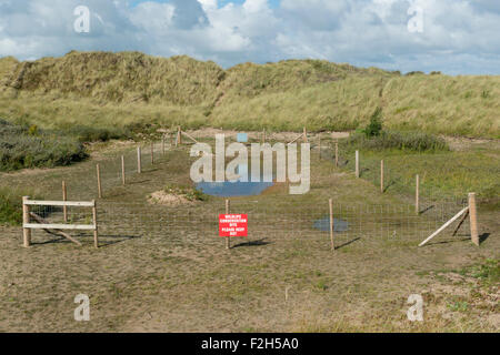 La signalisation sur une clôture autour de la conservation de la faune sauvage à l'Gronant dunes dans Flintshire, près de Prestatyn dans Denbighshire. Banque D'Images