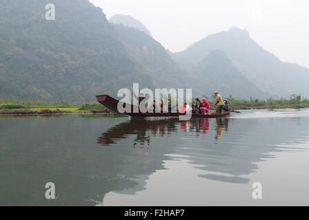D'hommes et de femmes de voyager dans un bateau traditionnel le 19 janvier 2008 à la rivière Rouge, au Vietnam. Banque D'Images
