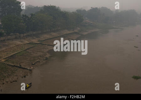 Pekanbaru, dans la province de Riau en Indonésie. 19 Septembre, 2015. Dans cette photo prise le 18 septembre 2015. Un pêcheur passant alors que haze des feux de forêt à l'échelle du fleuve Siak III, à Pekanbaru, dans la province de Riau en Indonésie. L'Asie du Sud-Est a été enveloppée de brouillard qui a dévasté de vastes régions de la foresterie en Indonésie pendant la saison sèche, provoquant des incendies qui se propagent la fumée suffocante et la pollution de l'air dans toutes les parties de l'Indonésie et les pays voisins à l'ouest. Crédit : Ivan Damanik/Alamy Live News Banque D'Images