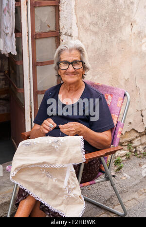 Vieille Femme broderie lefkaritika (traditionnel) dentelle au regard de sa boutique à Lefkara. Chypre. Banque D'Images