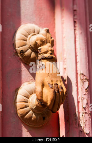 Old rusty heurtoir en forme de main sur la porte en bois rose libre. Lefkara. Chypre. Banque D'Images