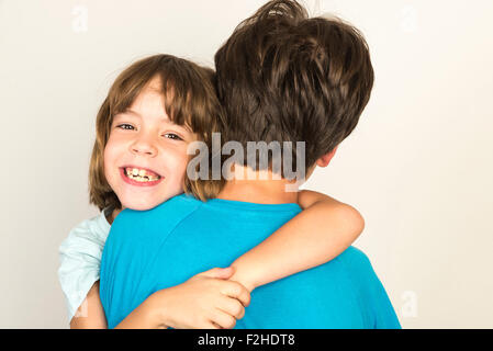 Garçon avec son sister smiling at home isolé sur fond blanc Banque D'Images