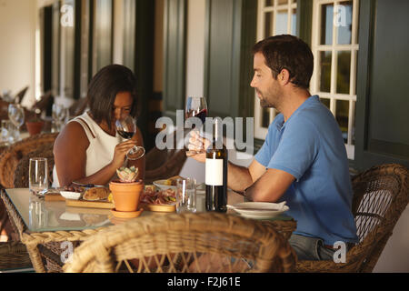 Young couple sitting at table vin rouge dégustation au restaurant de l'établissement vinicole. Couple à la dégustation de vins avec woman smelling vin. Banque D'Images