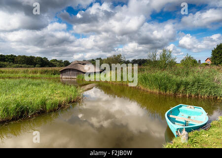 Belle maison de bateau de chaume et bateau à rames sur la Hickling large à Norfolk Banque D'Images