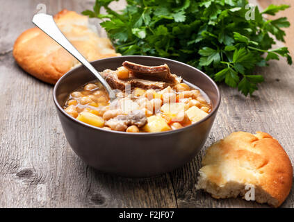 Soupe au pois chiches et d'agneau, de pains plats, parsley on a wooden background Banque D'Images