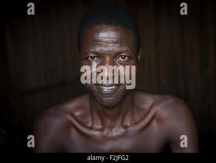 Le Bénin, en Afrique de l'Ouest, Onigbolo Isaba, homme de la tribu de holi couvert de tatouages et les cicatrices du visage traditionnel portrait Banque D'Images