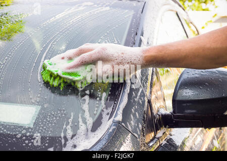 Homme avec éponge dans le lavage voiture Banque D'Images