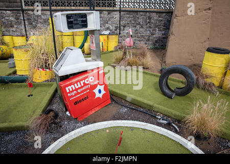 Cours du golfe fou à l'Dismaland Banksy à Weston super Mare avec pompe à carburant battues des barils de pétrole et les vieux pneus plus flamant rose Banque D'Images