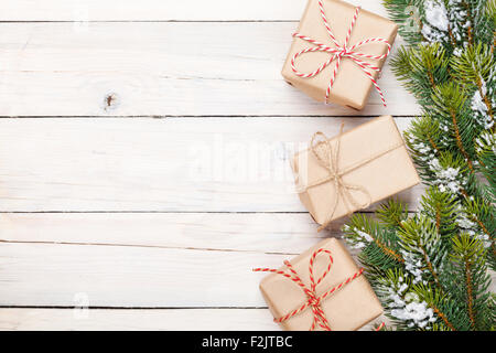 Sapin de Noël avec de la neige et des coffrets cadeaux sur planche de bois rustique with copy space Banque D'Images