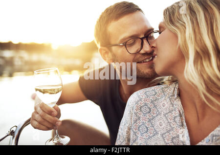 Couple Kissing doucement en buvant un verre de vin Banque D'Images