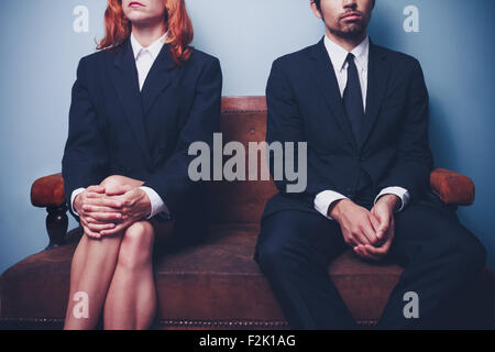 Young businessman and businesswoman sitting on a sofa Banque D'Images