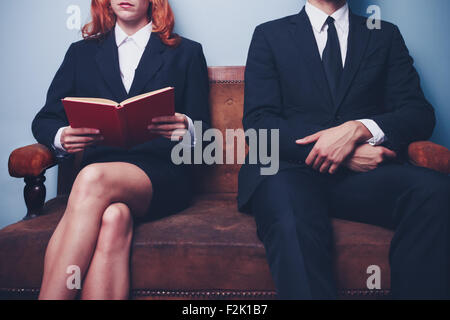 Young businesswoman and businessman sitting on sofa Banque D'Images