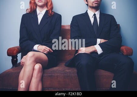 Young businessman and businesswoman sitting on a sofa Banque D'Images