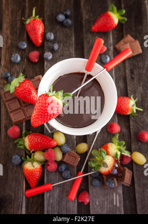 Fondue au chocolat avec les baies fraîches sur la table en bois Banque D'Images
