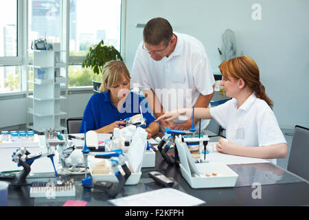 Trois techniciens dentaires travaillant dans un laboratoire dentaire Banque D'Images