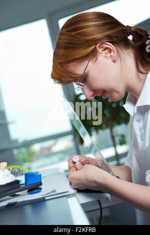 Technicien dentaire dentiers de broyage dans un laboratoire Banque D'Images