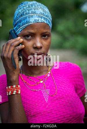 Le Bénin, en Afrique de l'Ouest, Gossoue, une belle femme tribu peul peul tatouée pause avec son téléphone portable Banque D'Images