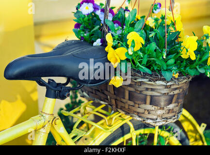Yellow Bicycle décorées avec un panier plein de fleurs Banque D'Images