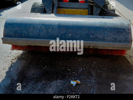 Sweeper mini pelle pièces jointes. La balayeuse balaie, recueille et déverse la saleté et les débris. Banque D'Images