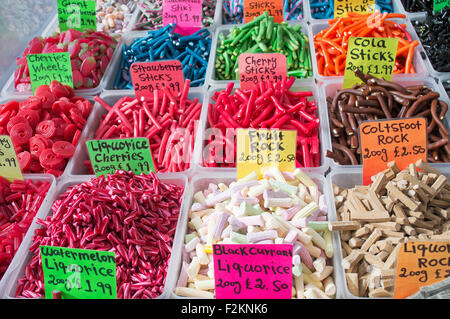 Boîtes de bonbons colorés en vente sur un étal de marché à Skipton, West Yorkshire, Angleterre Royaume-uni Banque D'Images