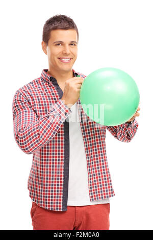 Shot vertical d'un jeune homme gai sauter un ballon vert et regardant la caméra isolé sur fond blanc Banque D'Images