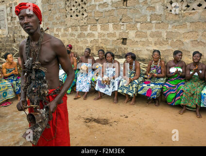 Le Bénin, en Afrique de l'Ouest, Bopa, adepte du vaudou avec une écharpe rouge en face d'une rangée de femmes au cours d'une cérémonie Banque D'Images