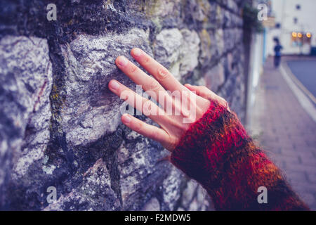 Woman's hand touching mur à l'extérieur Banque D'Images