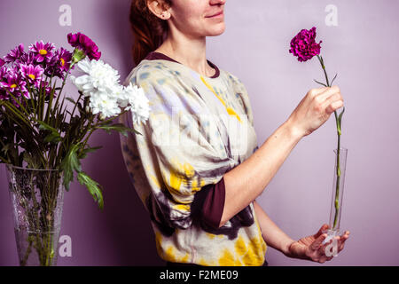 Jeune femme avec une seule fleur dans sa main Banque D'Images