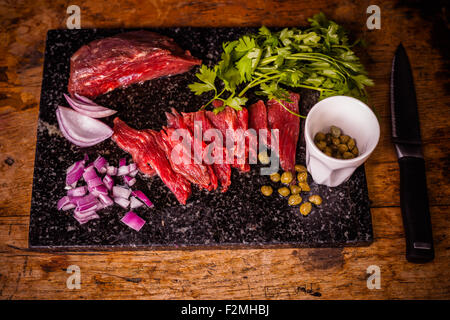 Steak tartare sur planche à découper Banque D'Images