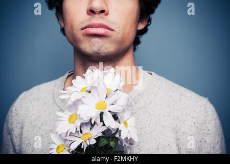 Jeune homme triste avec des fleurs Banque D'Images