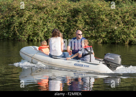 Journée en famille sur un bateau gonflable avec les enfants portant des gilets, England, UK Banque D'Images