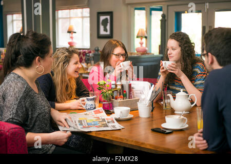 Un groupe d'amis avec le journal de dimanche dans un pub-restaurant familial UK Banque D'Images