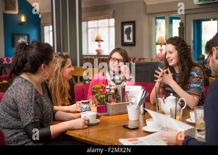 Un groupe d'amis avec le journal de dimanche dans un pub-restaurant familial UK Banque D'Images