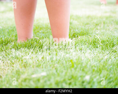 Kid pieds sur l'herbe. pieds d'un enfant s'enfoncer dans l'herbe. Concept de liberté Banque D'Images