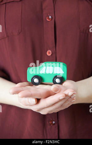 Woman Holding Model Voiture dans la paume de la main Banque D'Images