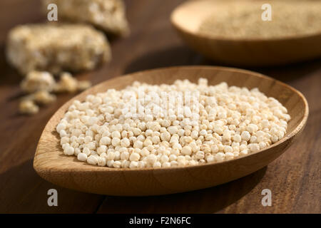 Le quinoa blanc sauté (lat. Chenopodium quinoa) sur les petites céréales plaque de bois brut, de céréales et de quinoa quinoa barre de céréales dans le dos Banque D'Images