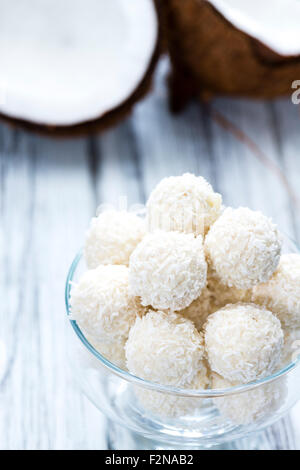 Partie de pralines de noix de coco sur fond de bois Banque D'Images