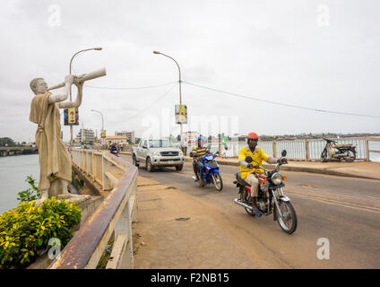 Le Bénin, en Afrique de l'Ouest, Cotonou, motos et voitures qui passent sur le pont sur le Lac Nokoué Banque D'Images