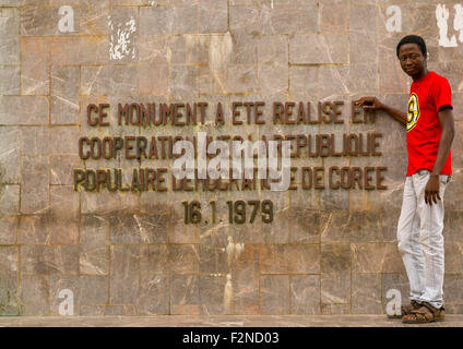 Le Bénin, en Afrique de l'ouest de Cotonou, Bénin, l'homme s'arrêtant en face de 1977 martyrs monument fait par des artistes nord-coréen Banque D'Images