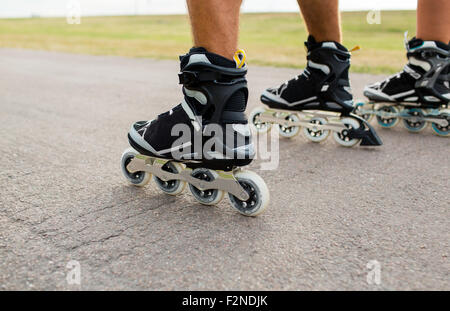 Close up de jambes en rollerskates patinage sur road Banque D'Images
