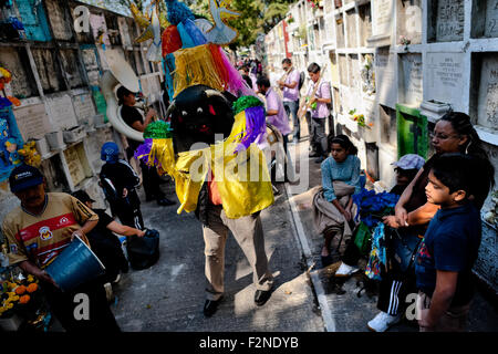 Un homme portant un costume bull effectue pendant le Jour des morts dans le cimetière de Morelia, au Mexique. Banque D'Images