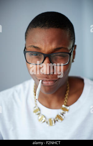 Close up of mixed race woman smoking cigarette Banque D'Images