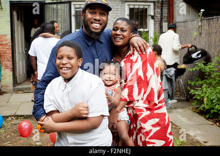 Family hugging at backyard barbecue Banque D'Images