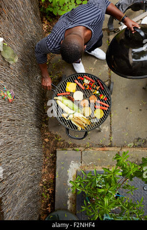 High angle view of African American man grilling at barbecue Banque D'Images