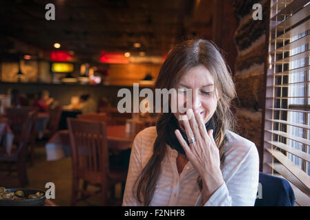 Caucasian woman laughing in bar Banque D'Images